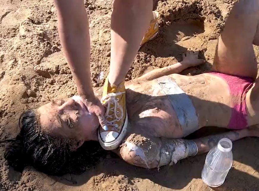 Girl throat fucked with hand and chocked with foot in the sand